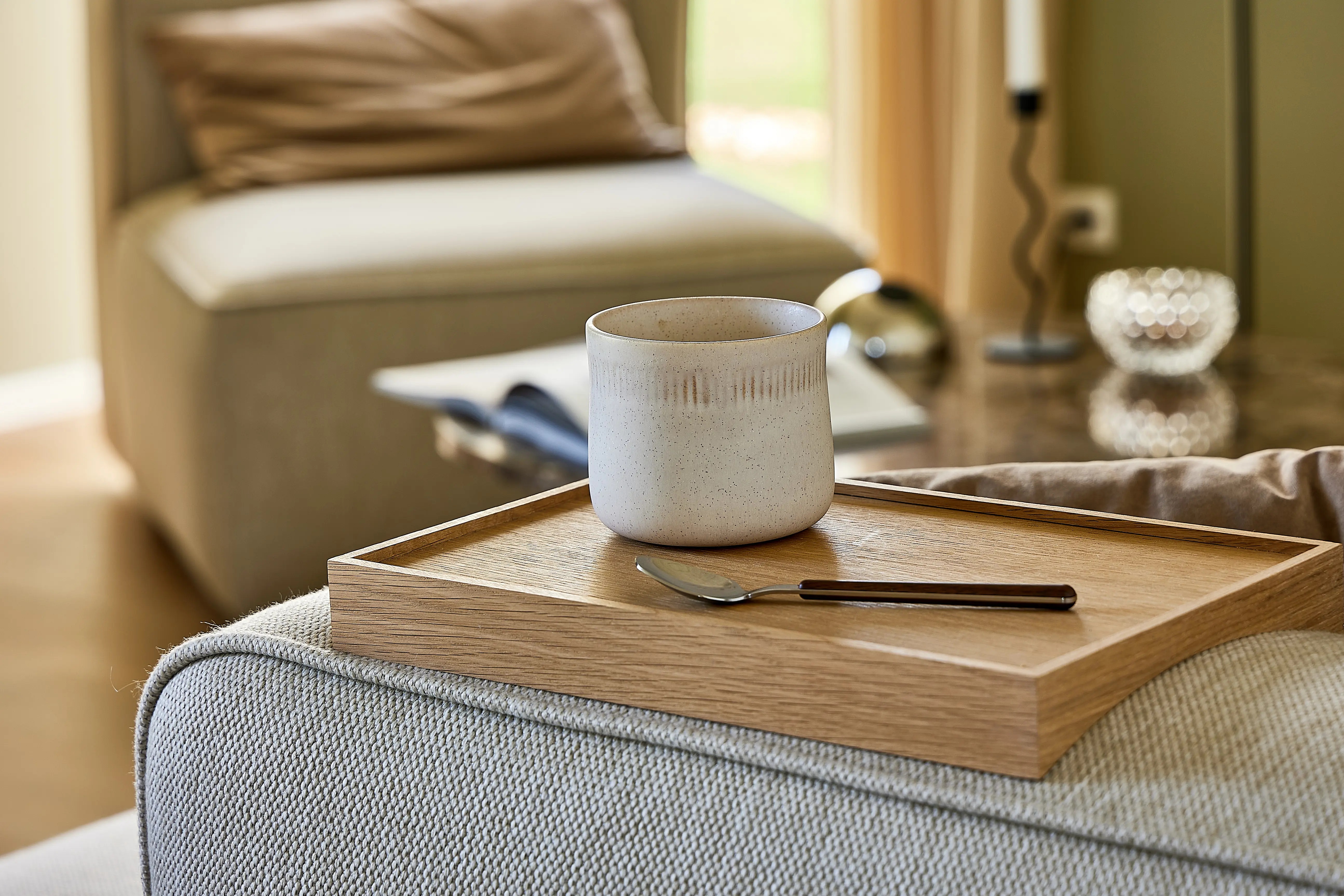 En kaffekop stående på et armlæn