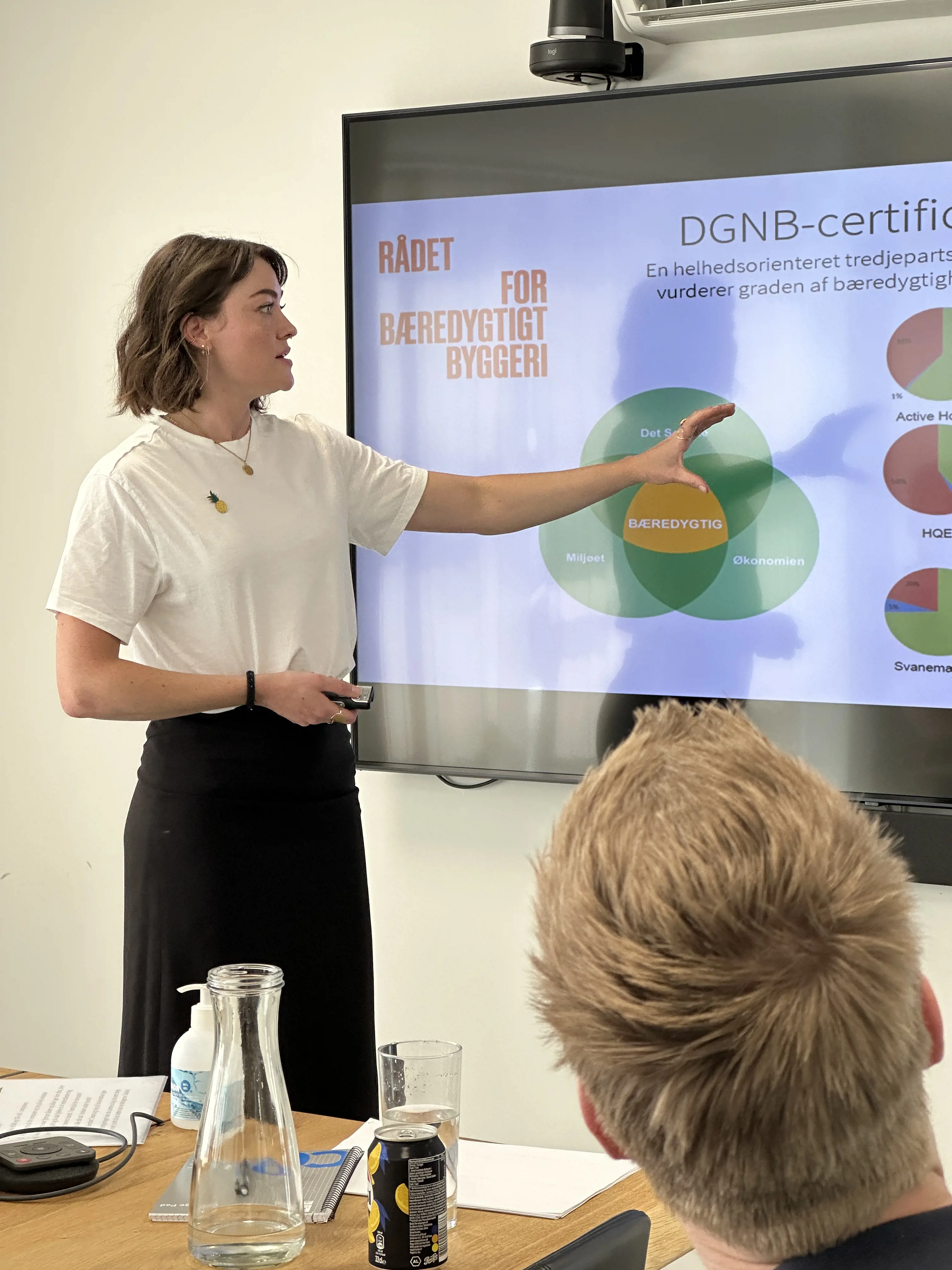 Kvinde står og fortæller om bæredygtighed og DGNB-certificering